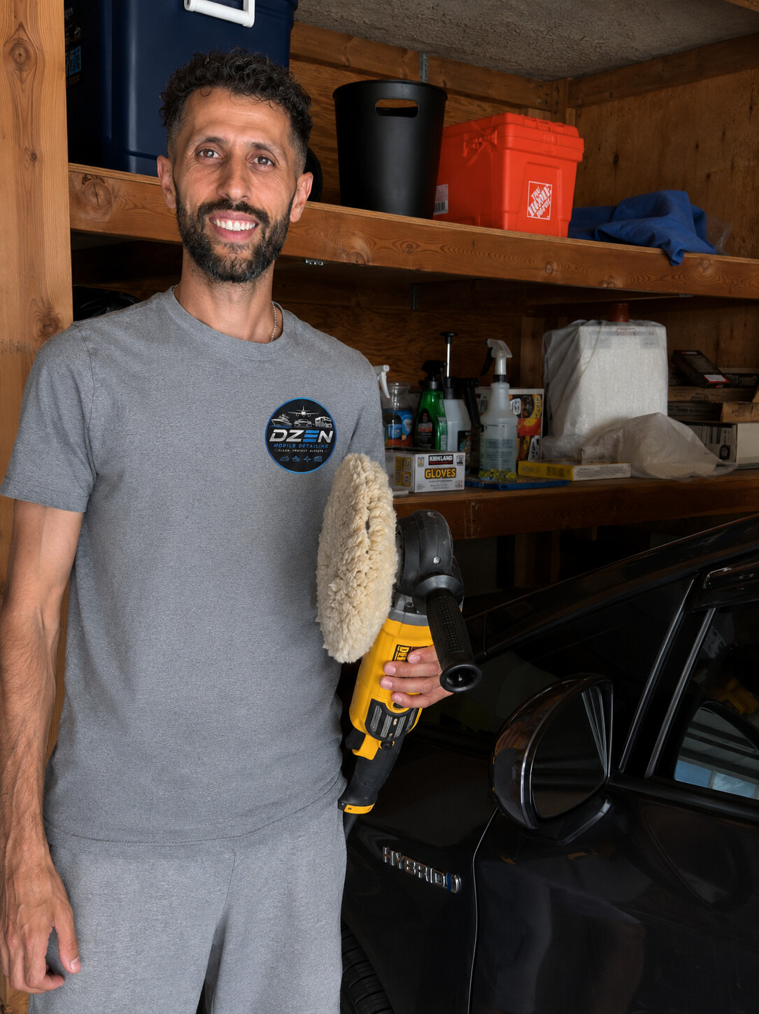 Kerop, owner of DZEN Mobile Detailing, with a rotary polisher next to a freshly polished car